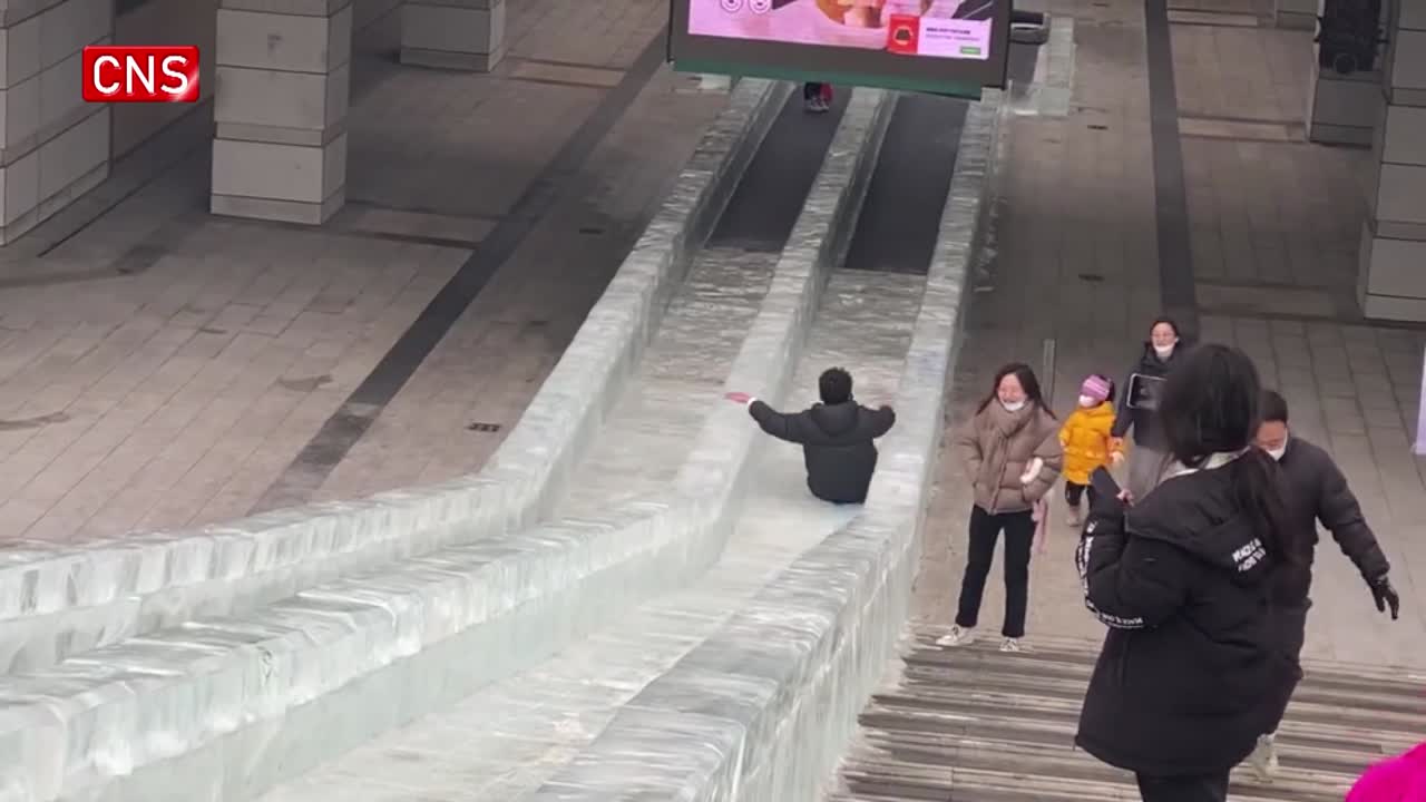 Residents enter shopping mall on ice slide in NE China