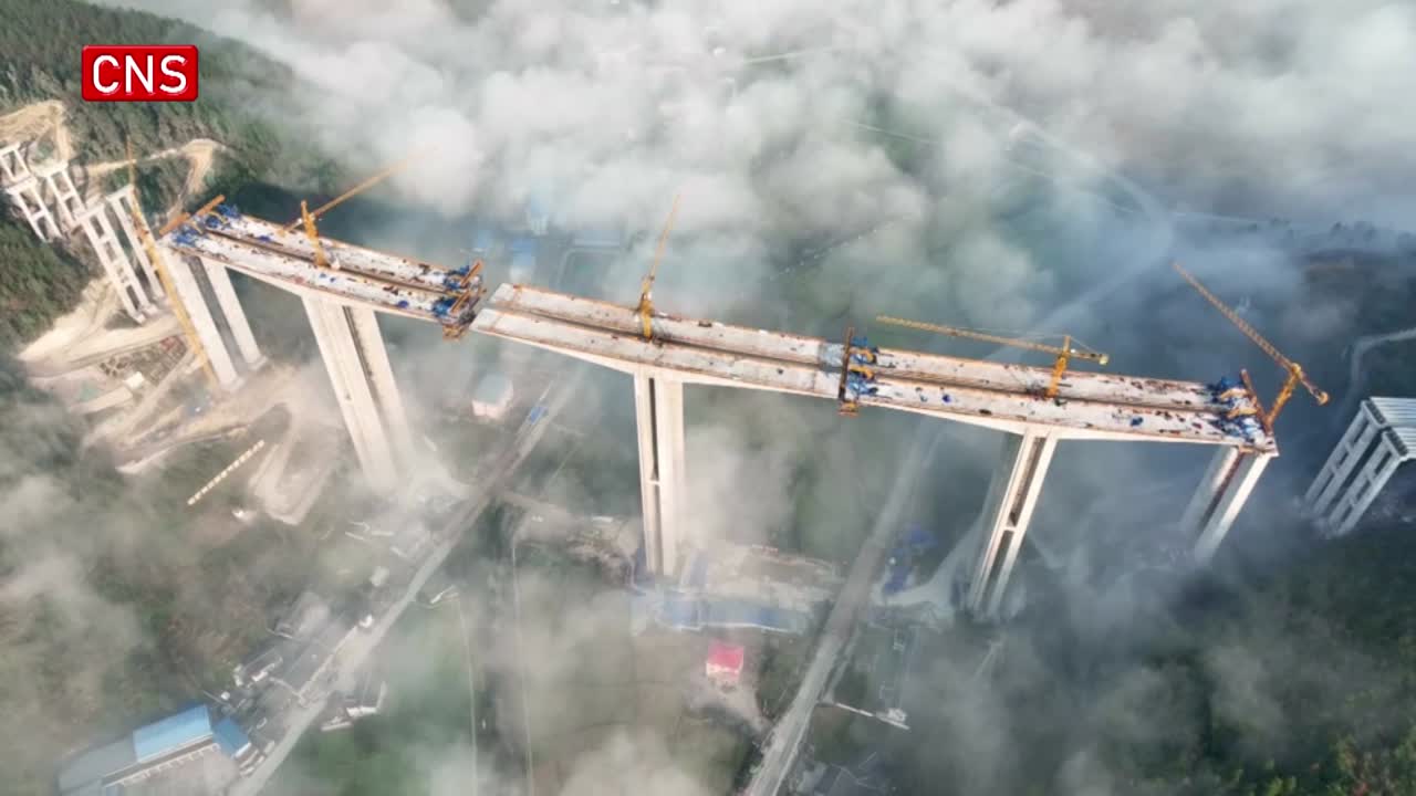 Cloud-shrouded Huangyujiang Bridge under construction in Guizhou