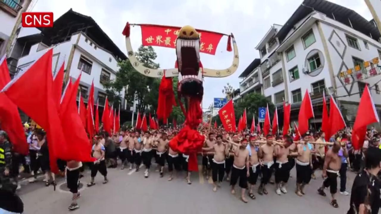 Over 2,000 men in SW China's Guizhou transport world's longest dragon boat to river
